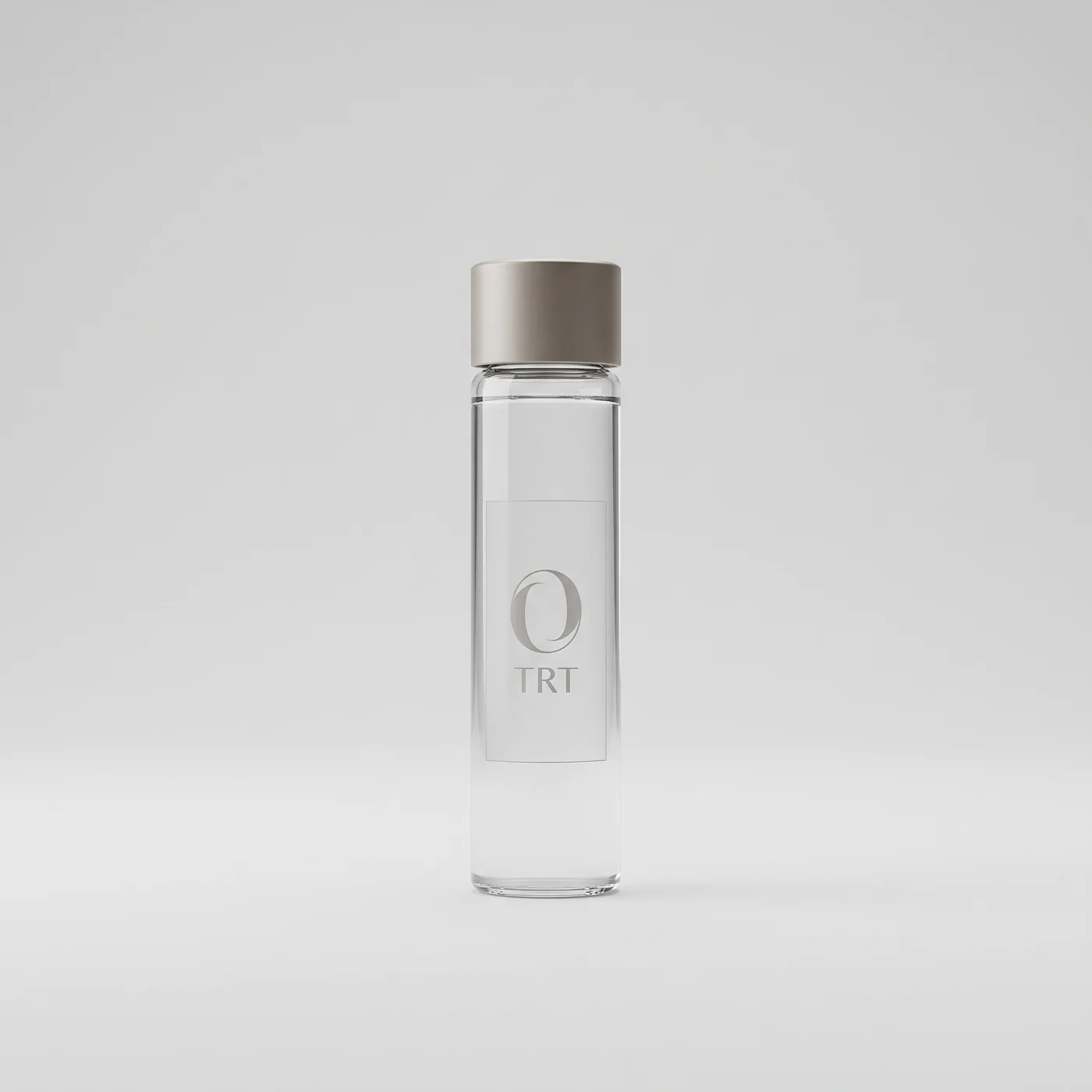 The TRT Optima dose vial: clear borosilicate glass with a brushed metal cap and an etched monogram.
